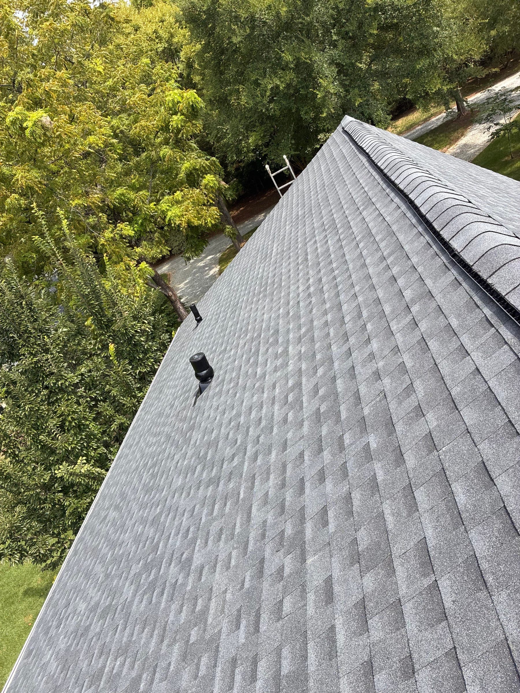 The same ridge finished with shingles and a capped ridge vent